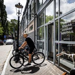 Kunden stehen vor verschlossenen Tueren im Fahrradgeschaeft VanMoof in Amsterdam