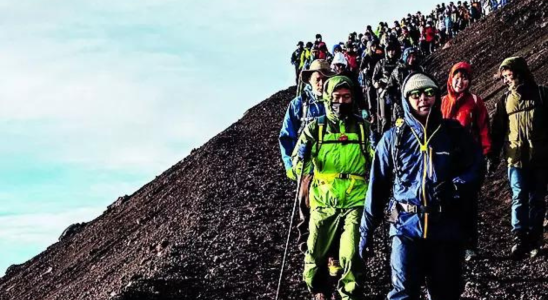 Japan blickt auf Bordsteine waehrend Touristenschwaerme den heiligen Berg Fuji