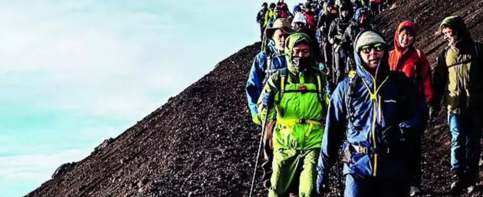 Japan blickt auf Bordsteine waehrend Touristenschwaerme den heiligen Berg Fuji