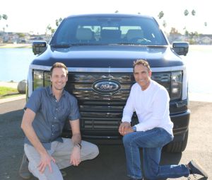 Ford-Manager Alan Clarke und AMP-Gründer Anil Paryani posieren vor einem Ford-Emblem.