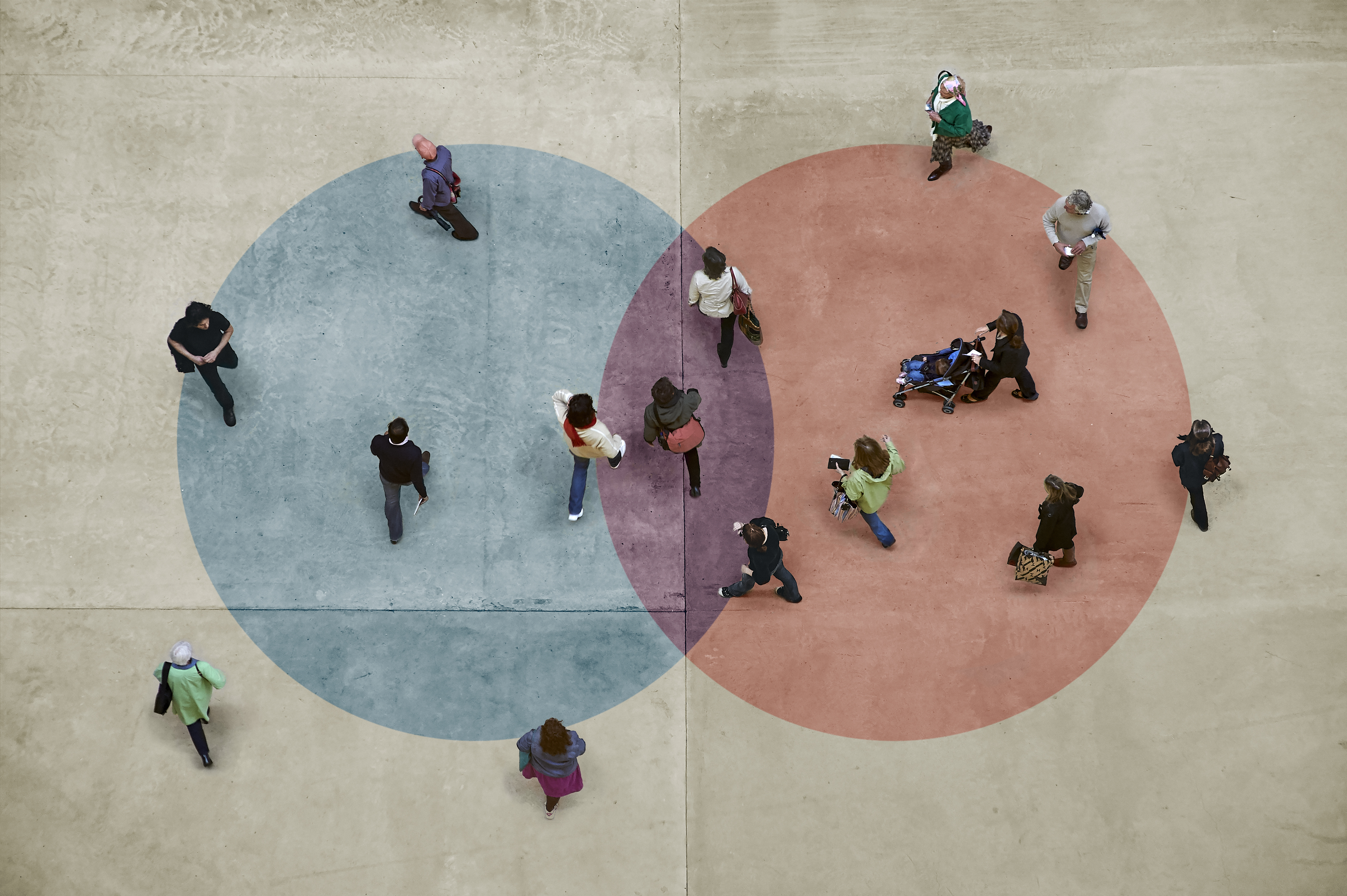 Bild überlappender blauer und roter Kreise mit Menschen, die in und um beide herum stehen.
