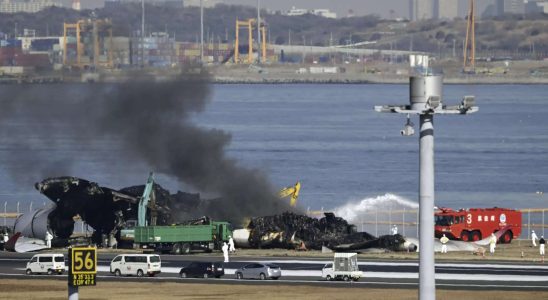 Japanische Sicherheitsexperten suchen nach Sprachdaten waehrend Arbeiter Flugzeugtruemmer von einer