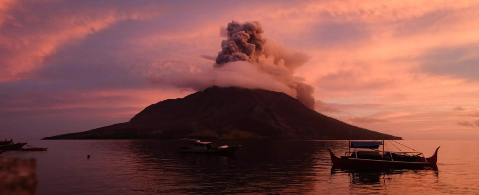 Chinesin rutscht beim Posieren fuer ein Foto in indonesischen Vulkan