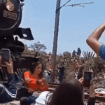 Frau beim Selfie Machen neben Oldtimer Zug in Mexiko getoetet