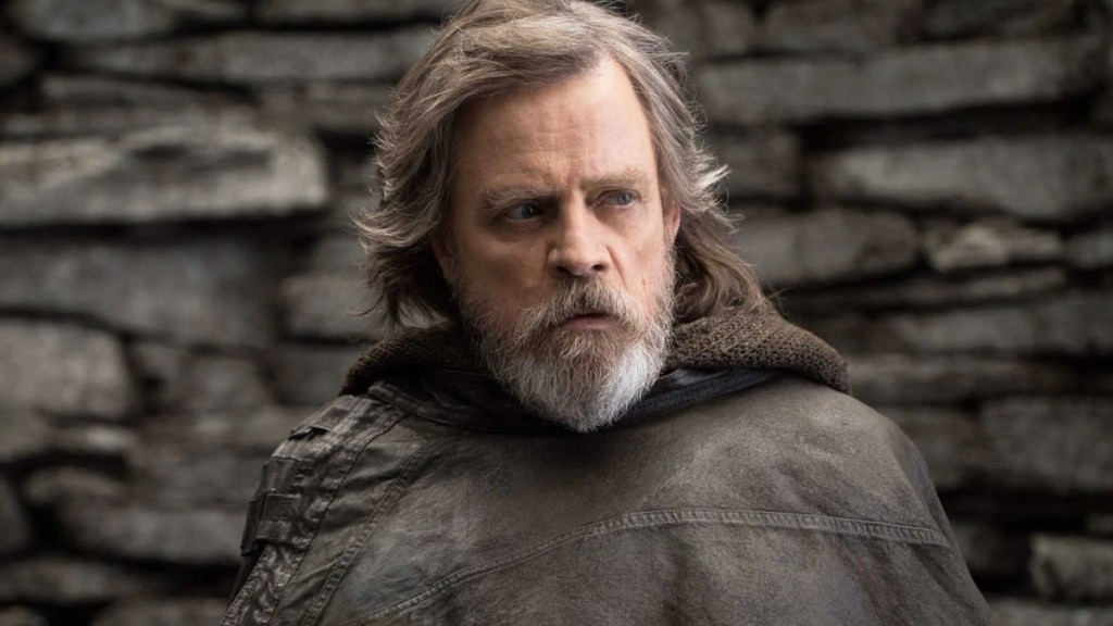 Luke Skywalker in Star Wars: Die letzten Jedi sieht grauhaarig und abgestumpft aus, trägt einen Lederkittel und runzelt die Stirn über jemanden außerhalb des Bildes