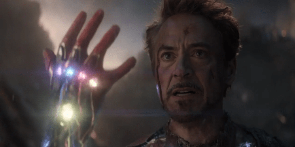 Ein Iron Man ohne Maske und mit dem Infinity Gauntlet hält in Avengers: Endgame seine Hand hoch.