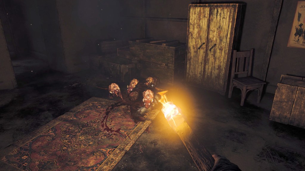 Amnesia: The Bunker, der Spieler hält als Teil eines Artikels über die besten Horrorspiele einen brennenden Stock vor eine Gruppe Ratten in einem Bunker