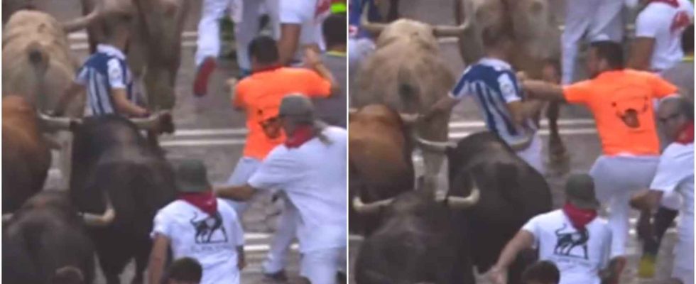 un coureur en pousse un autre contre les taureaux dans