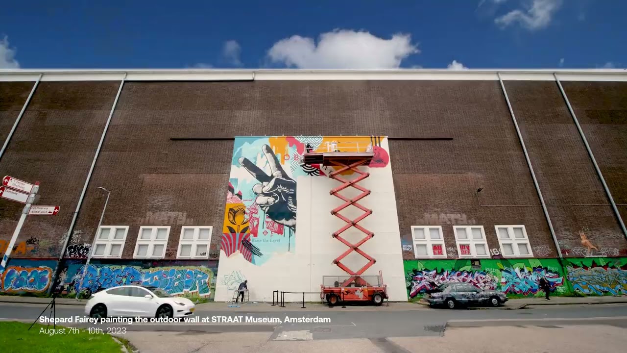 Image tirée de la vidéo : Shepard Fairey place une fresque murale à l'extérieur du musée STRAAT, en collaboration avec l'artiste de street art néerlandais Niels 