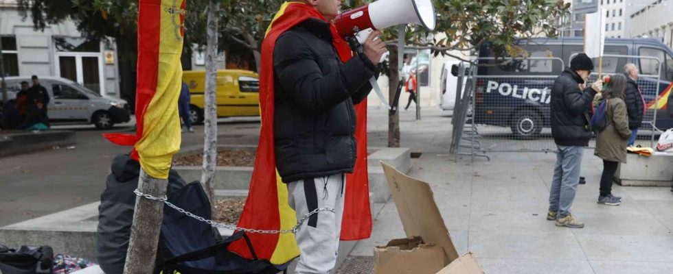 Un jeune homme senchaine devant le Congres avec un drapeau