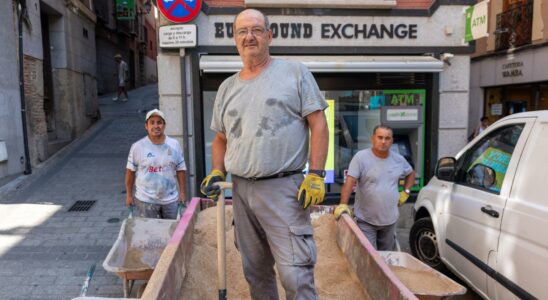 des macons a bout travaillant a 2 des touristes sans