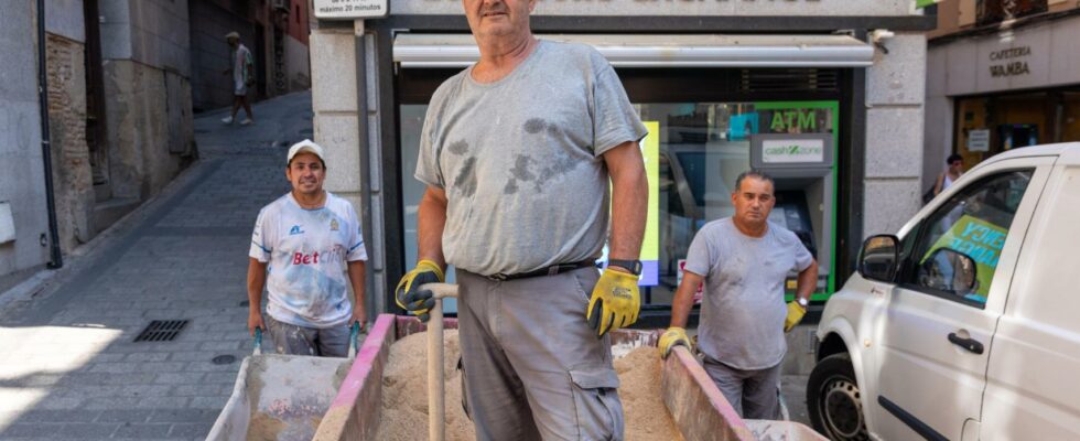 des macons a bout travaillant a 2 des touristes sans