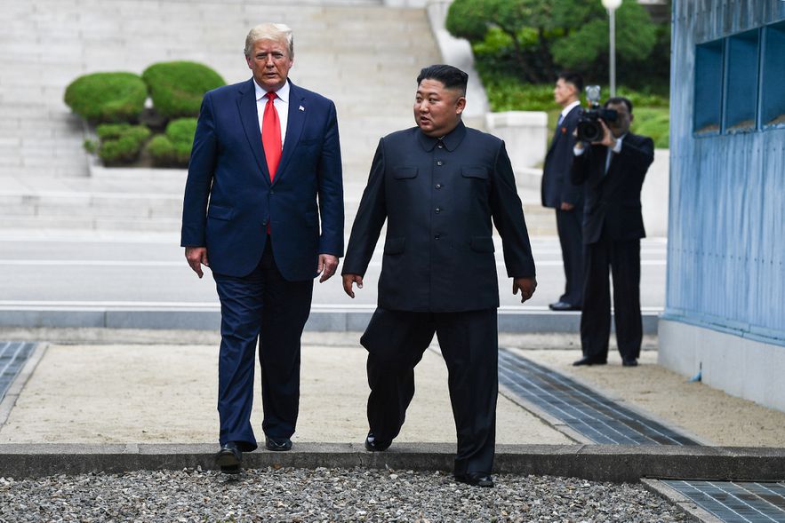 US President Donald Trump and North Korean leader Kim Jong Un cross the Military Demarcation Line separating North and South Korea at the Panmunjom Common Security Zone and Demilitarized Zone (DMZ) on July 30