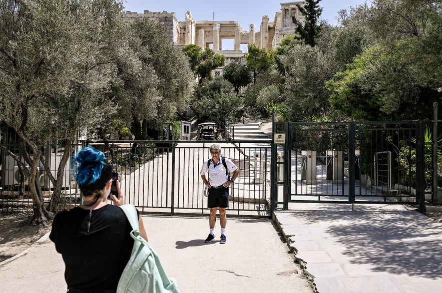 A tourist poses in front of the entrance to the Acropolis, which was closed due to a heat wave in Athens, July 14, 2023.