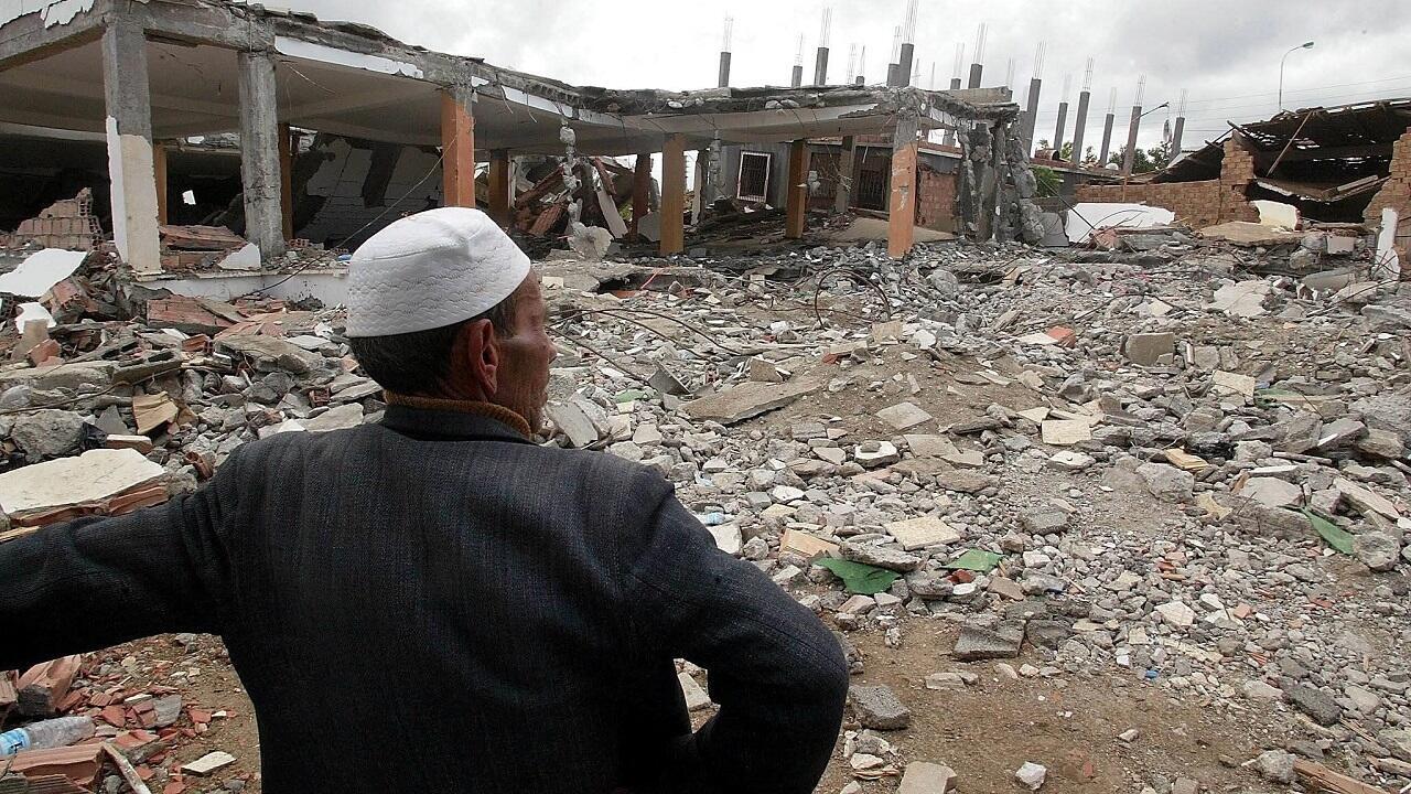 A man stands in front of the ruins of a building devastated by the May 2003 earthquake in Zemmouri, Algeria.