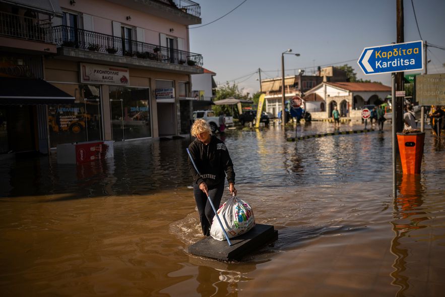 A woman carries her belongings to the flooded Greek village of Palamas, near Karditsa (center), September 8, 2023