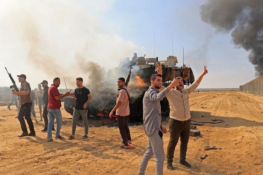 Palestinians take control of an Israeli tank after crossing the border into Israel from Khan Yunis, October 7, 2023 in the southern Gaza Strip.