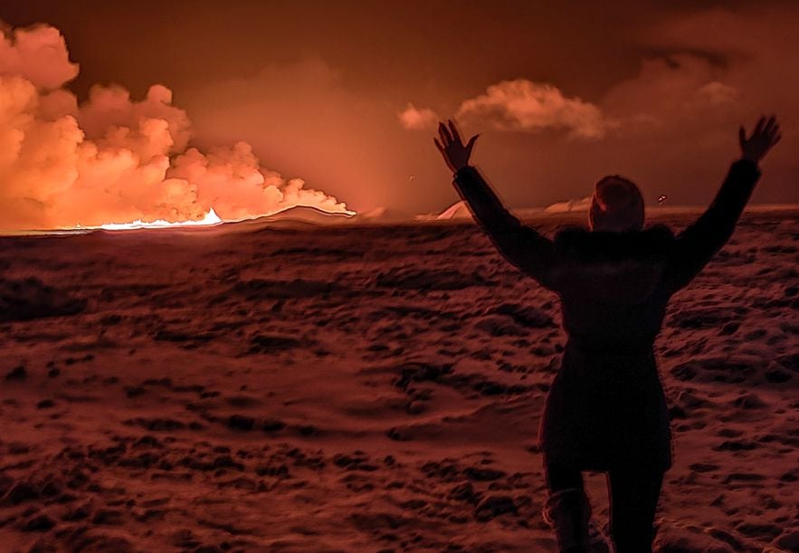 A resident watches smoke coming from a crack on the Reykjanes Peninsula, south of the capital Reykjavik, Iceland, December 18, 2023