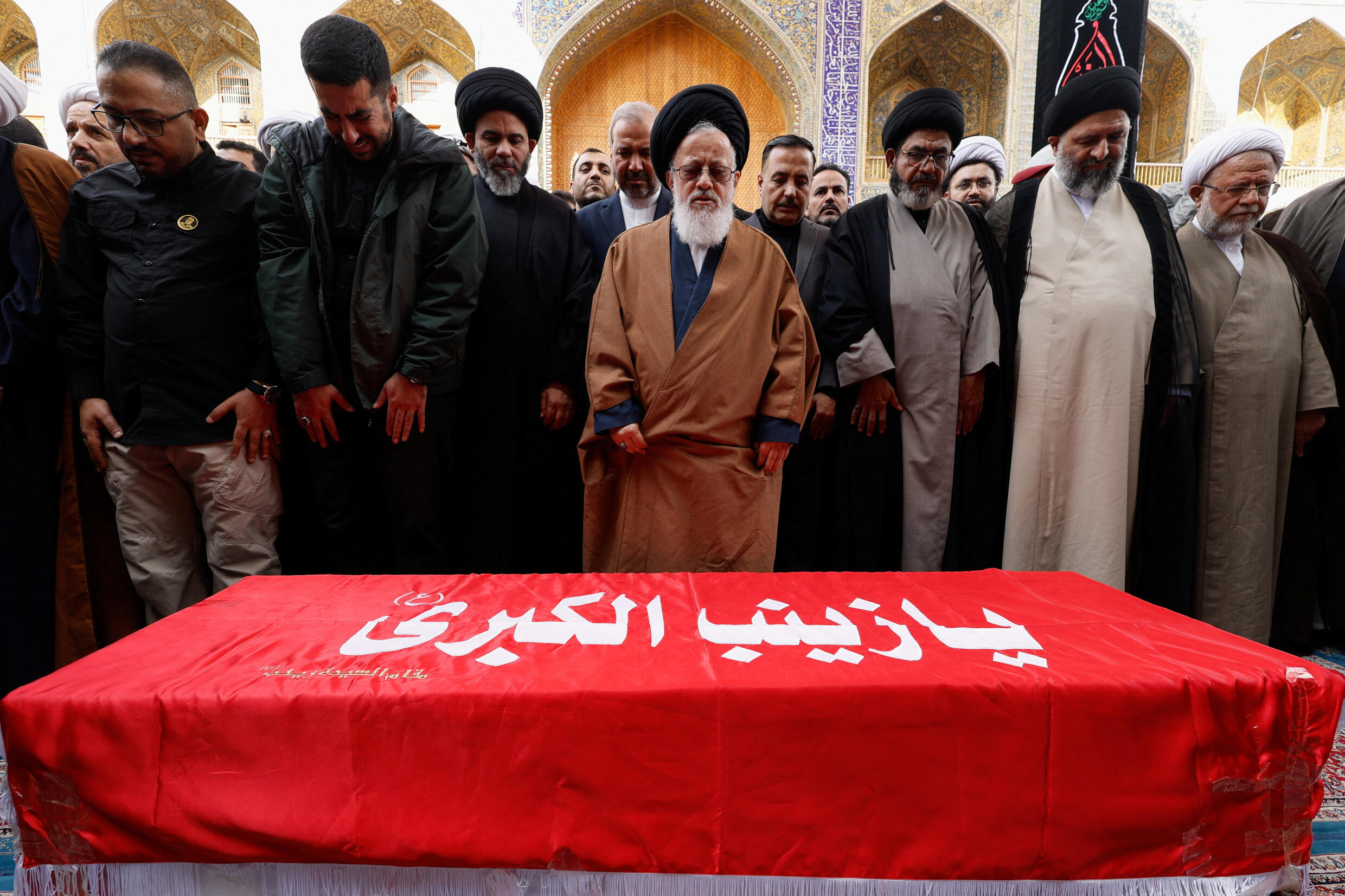 People pray in front of the coffin of General Razi Moussavi, killed by a strike in Syria on December 25, 2023.