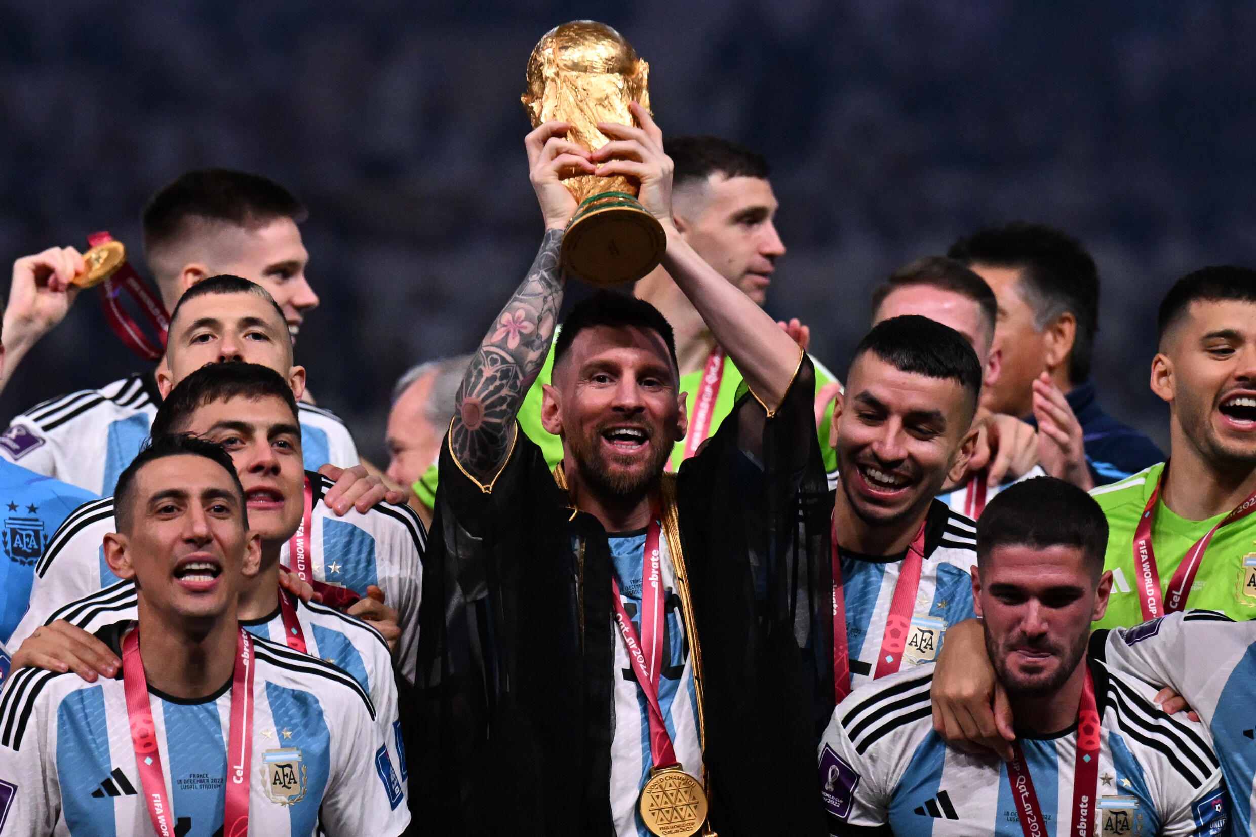 Argentine player Lionel Messi (c), surrounded by his teammates, lifts the FIFA World Cup won by Argentina against France on penalties, on December 18, 2022 at Lusail Stadium, Qatar