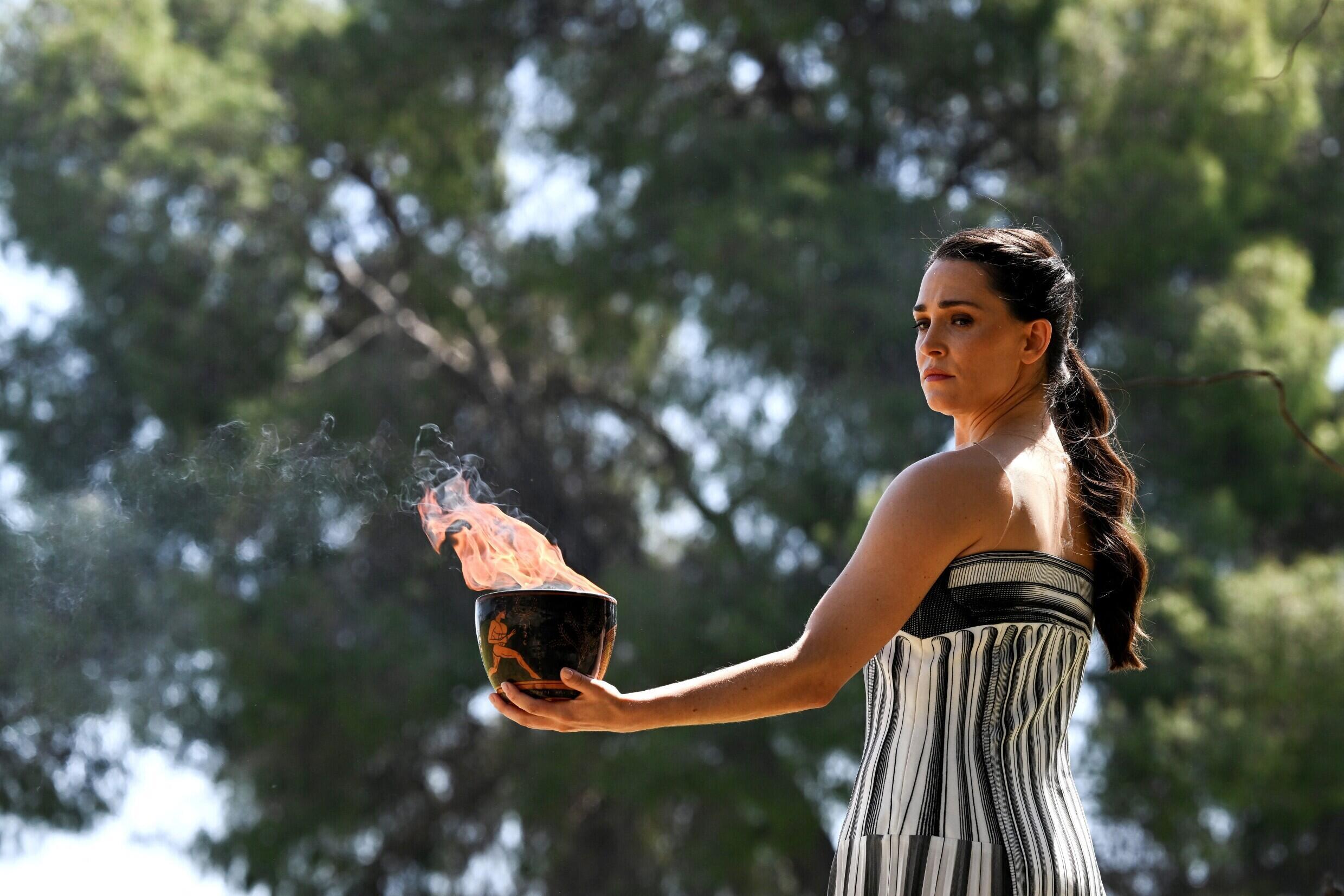 Greek actress Mary Mina, who plays the role of the High Priestess, holds the Olympic flame during the rehearsal of the flame lighting ceremony for the Paris 2024 Olympic Games at the ancient Temple of Hera at the archaeological site of Olympia, cradle of the ancient Olympic Games in southern Greece, on April 15, 2024.