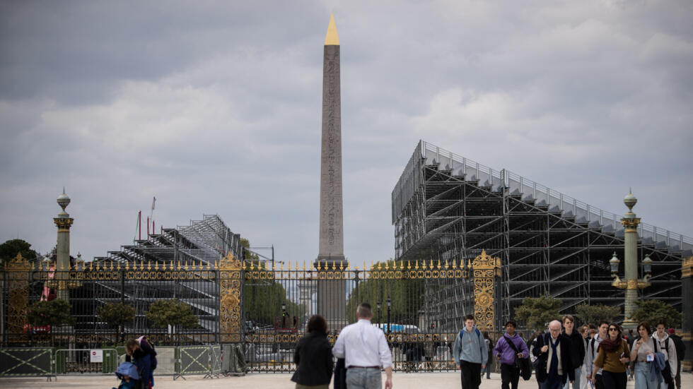 Tourists walk in the Jardin des Tuileries in front of the construction site of one of the sites of the next Olympic Games, Place de la Concorde, in Paris, April 26, 2024.