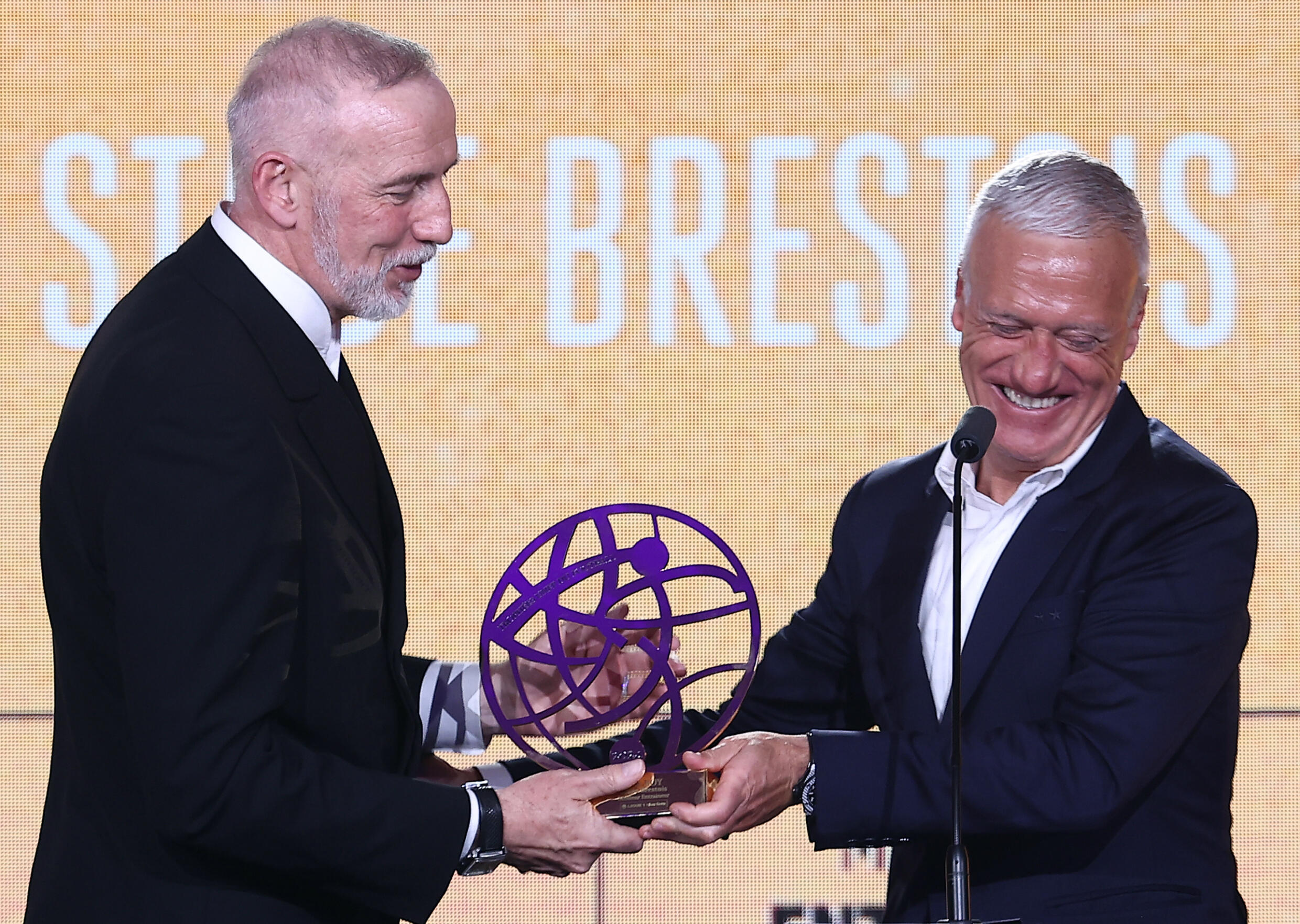 Brest coach Eric Roy receives the trophy for best League coach of the season from the Blues coach Didier Deschamps on May 13, 2024 in Paris