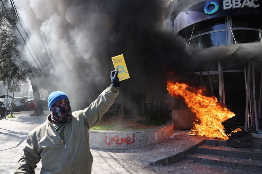 Protesters vandalize banks in Beirut on February 16, 2023, to protest the record drop in the Lebanese pound on the black market.