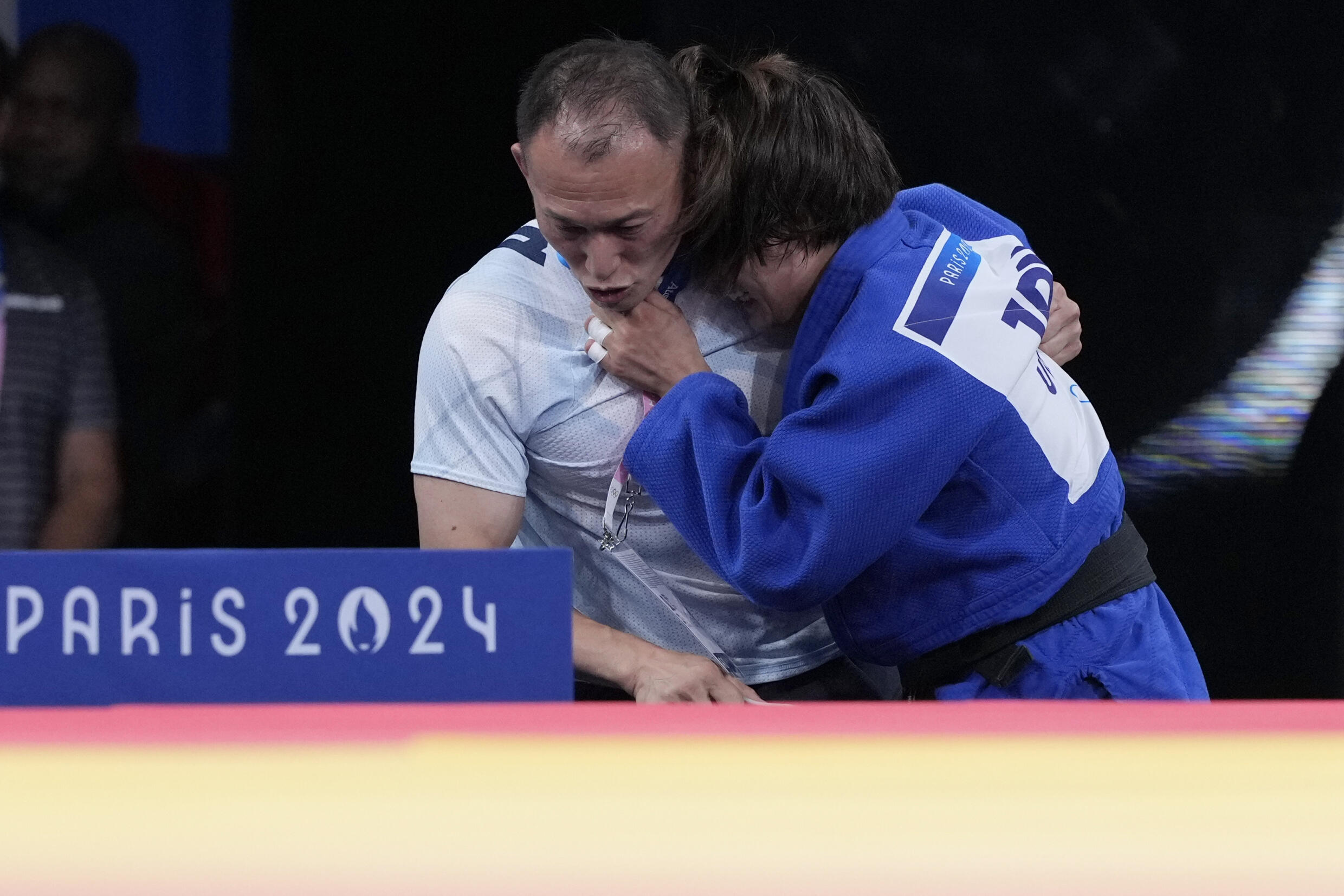 Devastated by her poor performance, Uta Abe collapsed next to her coach, who had to help her walk off the mat.
