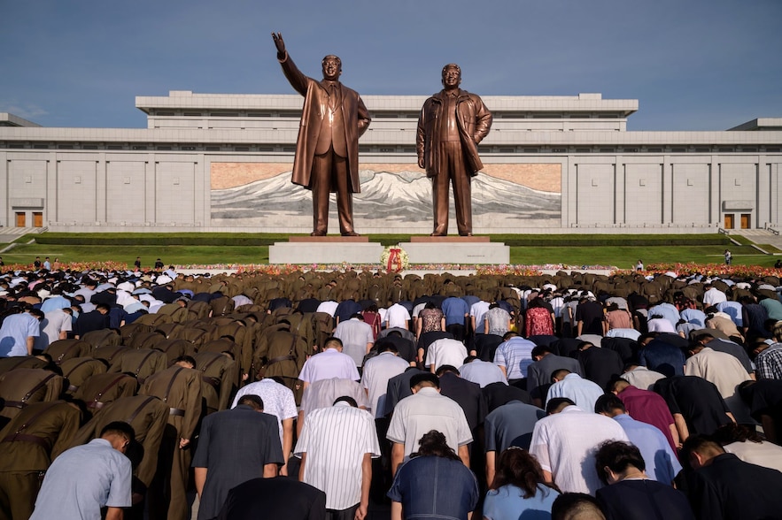 Crowds bow to statues of late North Korean leaders Kim Il Sung and Kim Jong Il on the 25th anniversary of Kim Il Sung's death in Pyongyang on July 8, 2019.