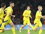 Ukrainian players take a stand while fanning the goal on