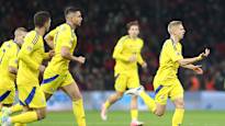 Ukrainian players take a stand while fanning the goal on