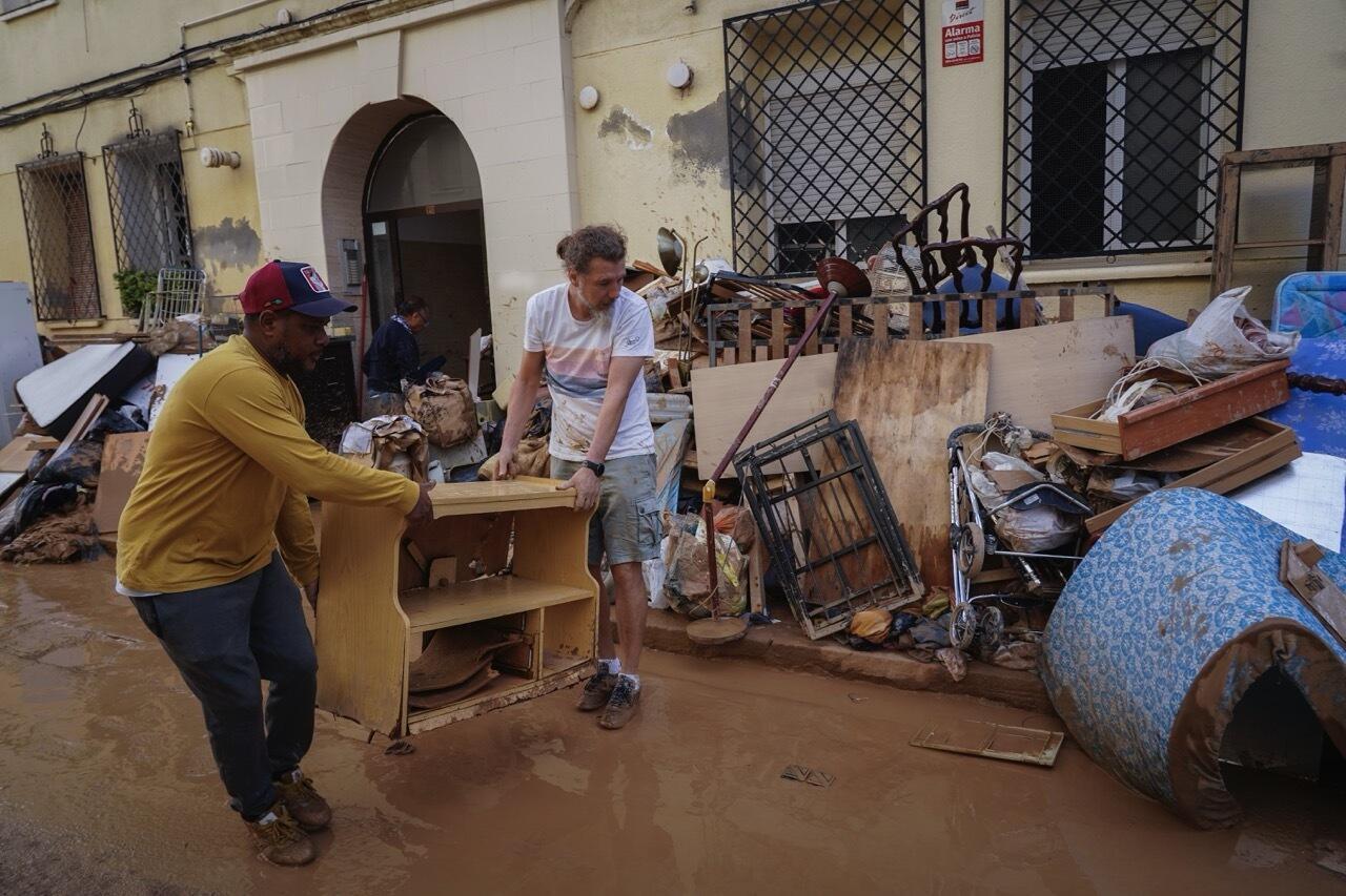 Residents move furniture as they attempt to clean a flooded area in the La Torre neighborhood of Valencia, Spain, Friday, November 1, 2024.