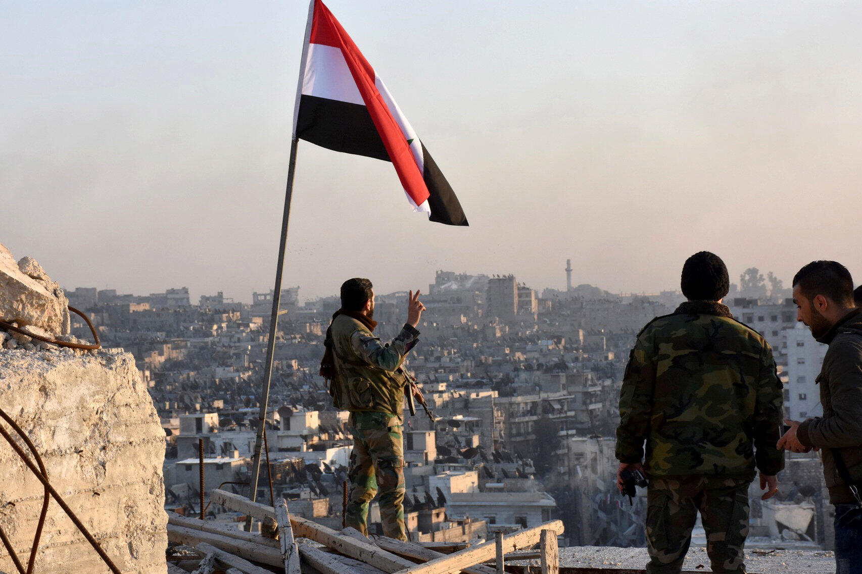 A Syrian regime soldier makes the V for victory after the capture of the Al Sakhour neighborhood in Aleppo, November 28, 2016.