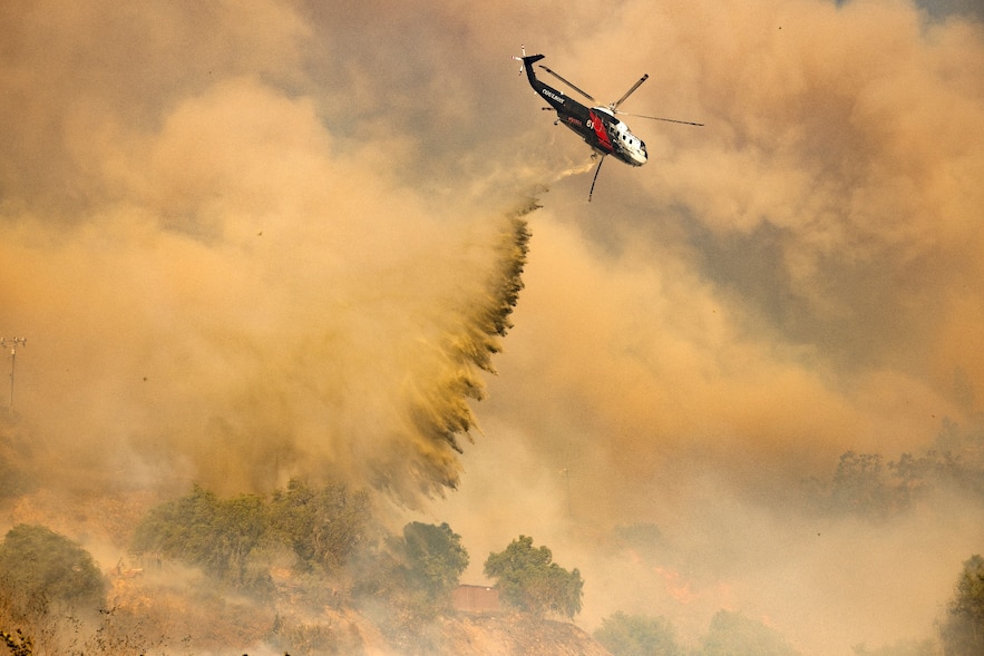 A firefighting helicopter performs a water drop over the Mountain Fire in Camarillo, California, November 6, 2024