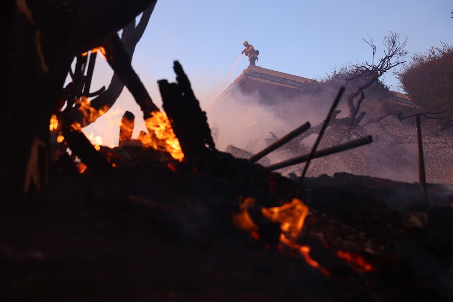 A firefighter fights against the embers of a fire in the Pacific Palisades neighborhood, on the outskirts of Los Angeles, on January 7, 2025