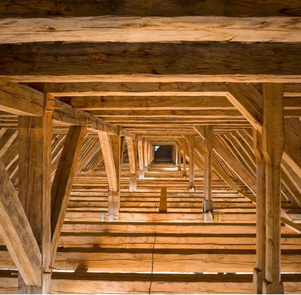 Large attic - framework of the nave rebuilt by hand by the carpenters.